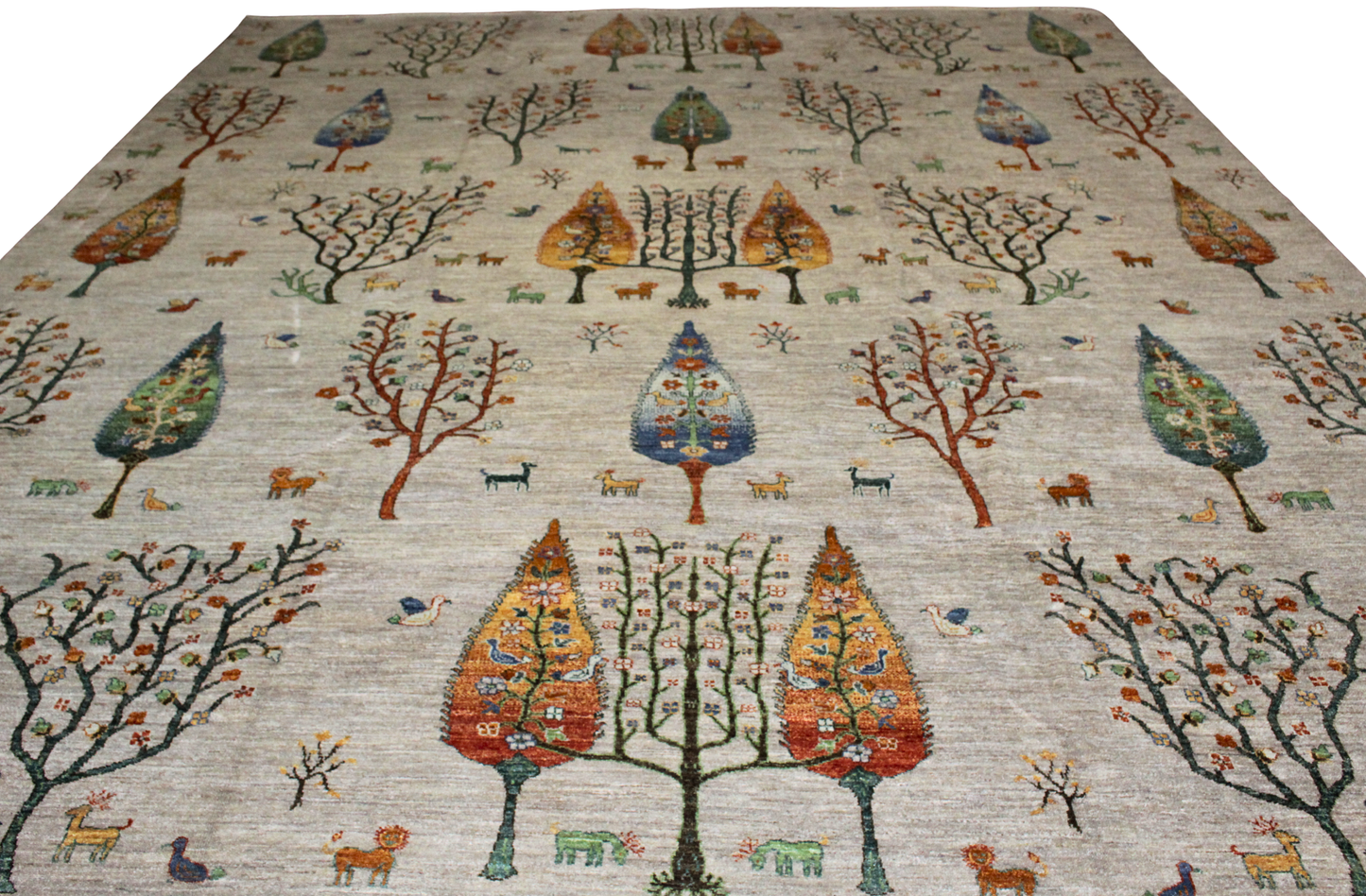Decorative rug with tree and animal pattern on a plain background