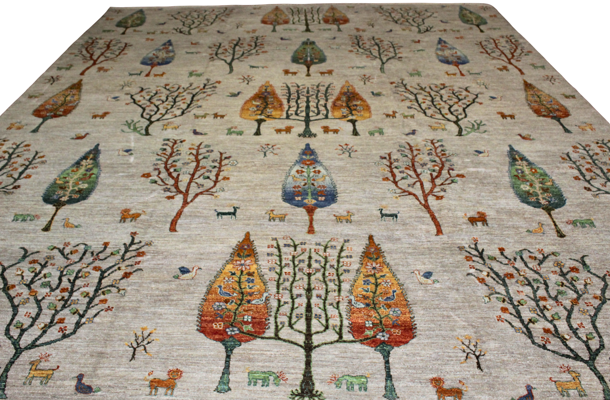 Decorative rug with tree and animal pattern on a plain background