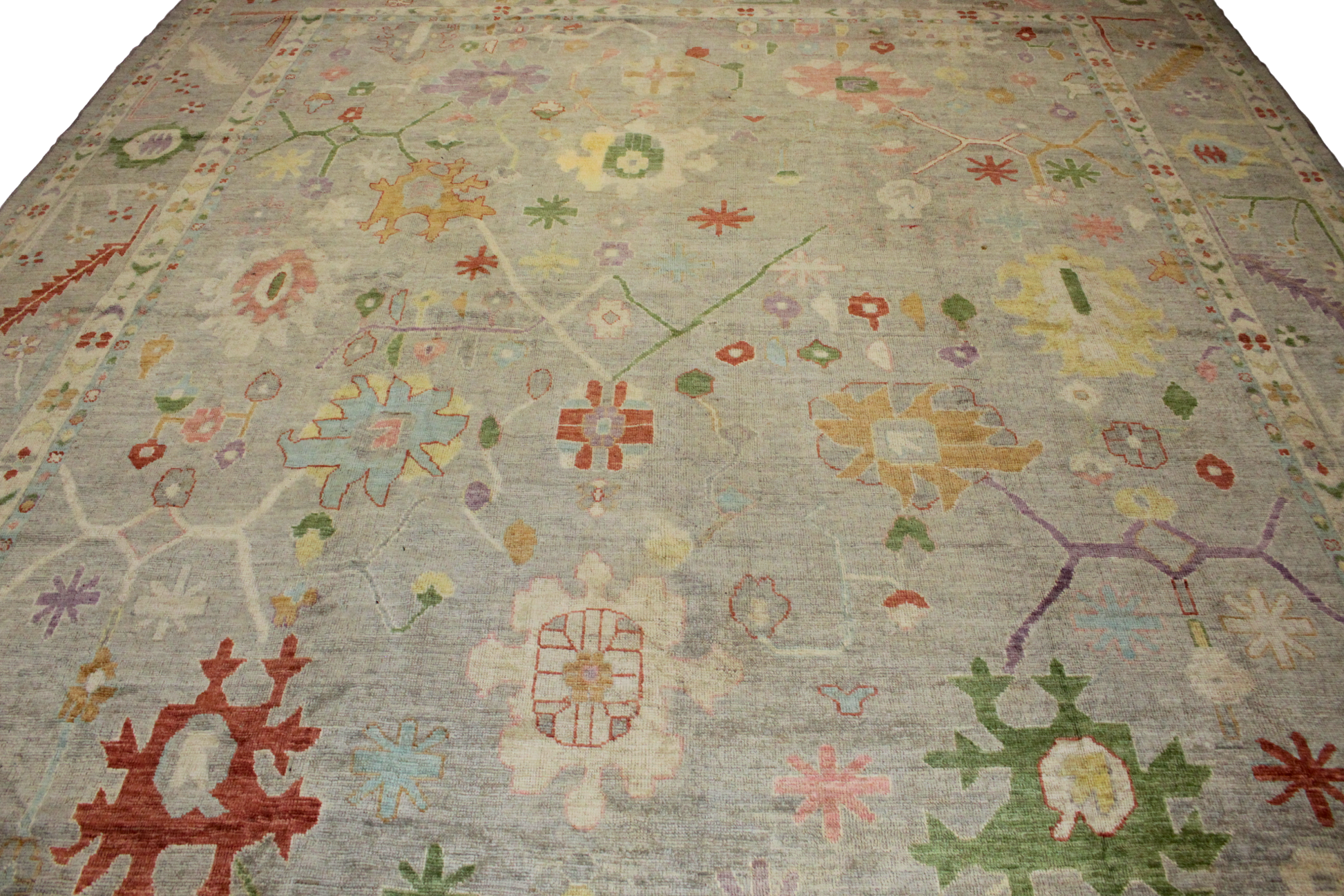 Hand-knotted Afghan Oushak rug in soft blush, stone, and ivory. This 11′9″ × 14′6″ wool rug brings gentle beauty and warmth to curated interiors.